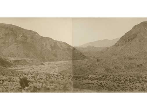 Impressive panoramic view of the typical bare landscape in the Khyber Pass, with some traces of tracks. A dry river bed at the foot of the left hill.