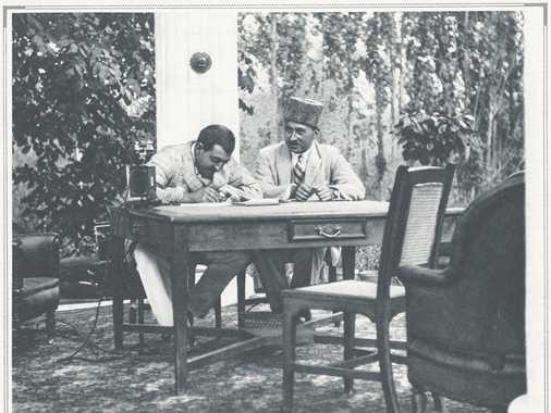 King Amanullah Khan (1892-1919-1929-1960), son of Amir Habibullah Khan (11.1.1.2), sitting at a table, beside Mohammad Wali Khan, son of Abul-Fayz from Darwaz, in the garden pavilion beside the koti sorkh in Paghman.