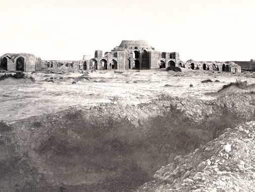 A domed structure made from burned bricks, which was never finished. It consists of a central two-storied building and two single-storied wings. The interpretation is either that it was intended to become a caravan saray or a government college. In the foreground a water channel between high dams.
