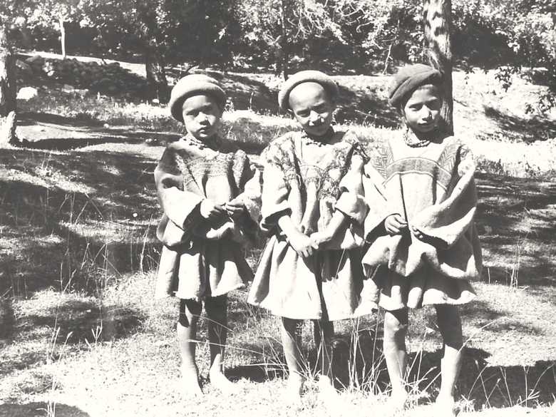 Drei Kalash-Kinder in reinlicher, mit Stickereien verzierter Kleidung.